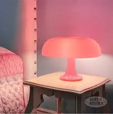 Pink aesthetic lamp on a white nightstand in a serene bedroom setup, casting a warm glow